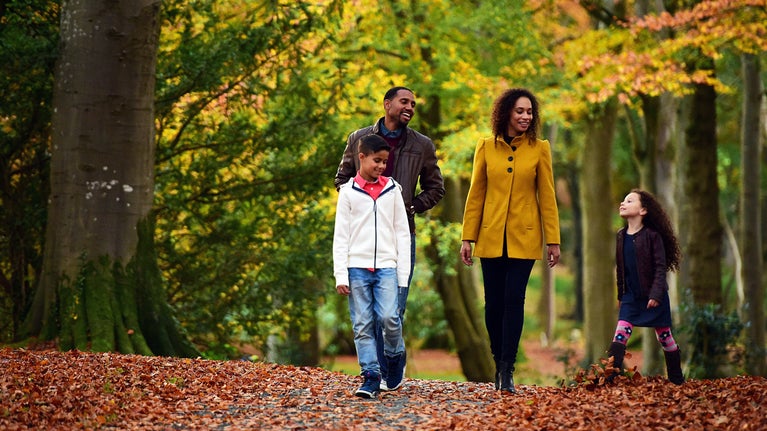 Family walking in Rowallane Garden, County Down, surrounded by autumnal colours